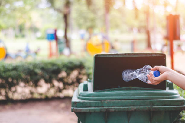 istock Cropped Hand Throwing Bottle In Garbage Can 1059422884