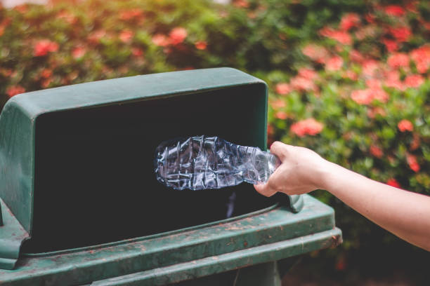 istock Cropped Hand Throwing Bottle In Garbage Can 1059422924