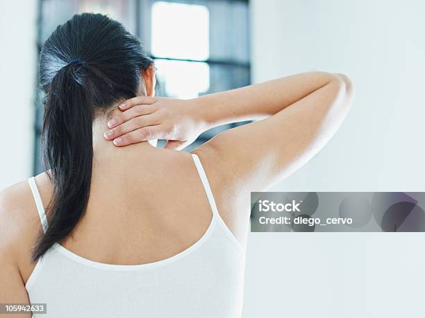 Woman In White Touches Neck Worryingly Stock Photo - Download Image Now - Rear View, Rubbing, Back