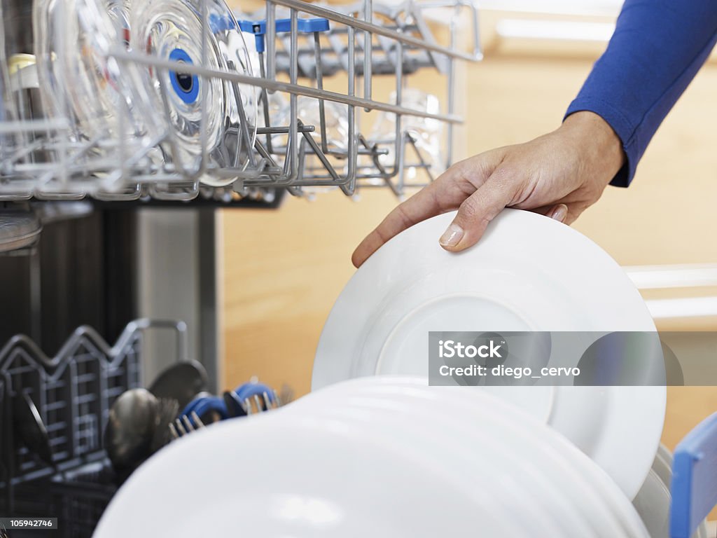 woman doing housework close up of woman in kitchen using dishwasher Plate Stock Photo