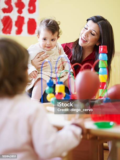 Due Bambine E Femminile Insegnante Di Scuola Materna - Fotografie stock e altre immagini di Educazione di scuola materna