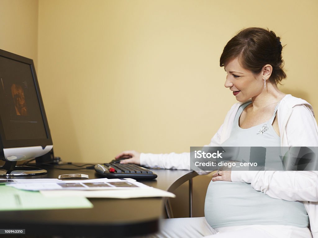 Mujer embarazada mirando en las exploraciones - Foto de stock de 20 a 29 años libre de derechos