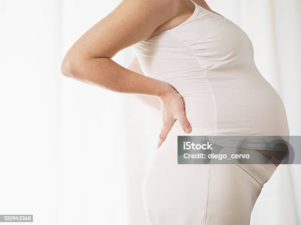 Pregnant Woman Holding Her Back Stock Photo - Download Image Now - Backache, Pregnant, Relief - Emotion