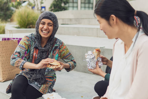 Young muslim woman out shopping and having a bite to eat with friends stock photo
