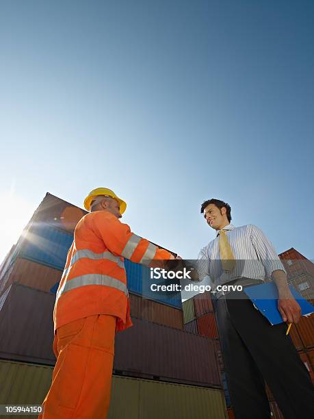 Businessman And Manual Worker With Cargo Containers Stock Photo - Download Image Now