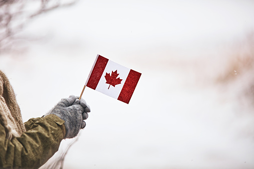 Woman holding Canadian flag in snowy scene