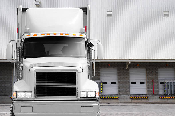 Truck at loading dock. White truck with loading dock in the background. loading bay stock pictures, royalty-free photos & images