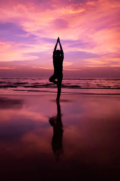 Photo of Silhouette of a young man meditating at sunset