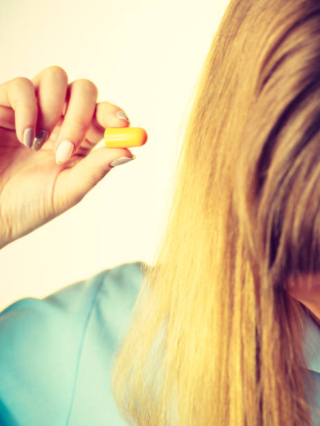 istock Woman holding protective earplugs 1059494724