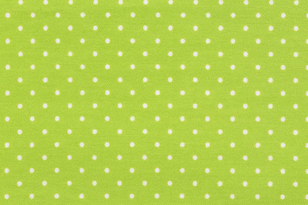 istock White dot over yellow polka dot fabric background and texture. 1059501784