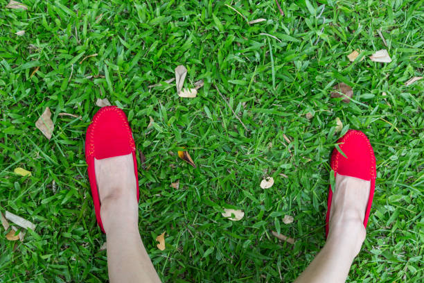 istock Red shoes girl on green grass 1059501818