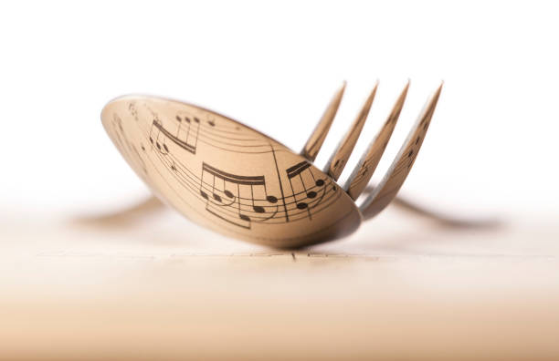 Music and cook. Musical score reflected into cutlery.
