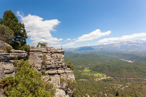 Young man standing on top of cliff.