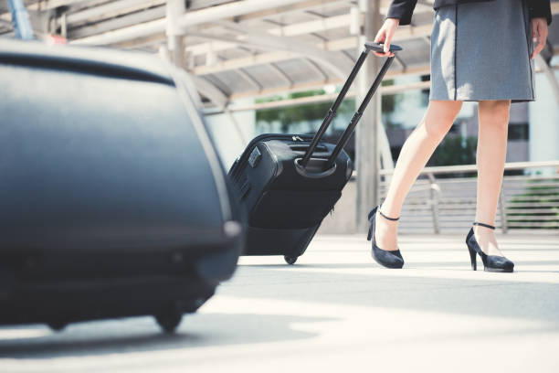istock Businesswoman (lower part) walking and pulling luggage 1059513056