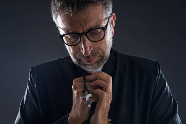 istock Priest praying hands with rosary beads 1059516628