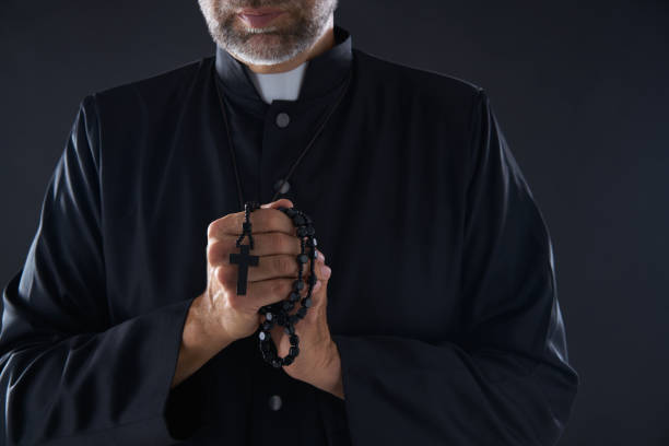 istock Priest praying hands with rosary beads 1059516728