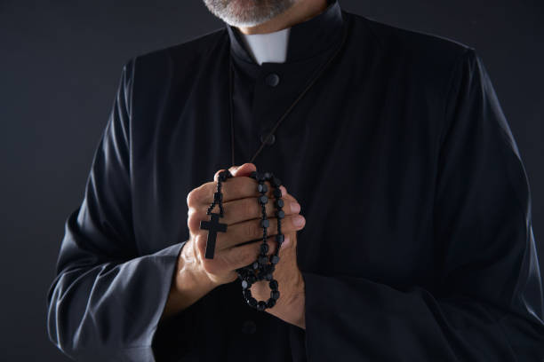 istock Priest praying hands with rosary beads 1059516734