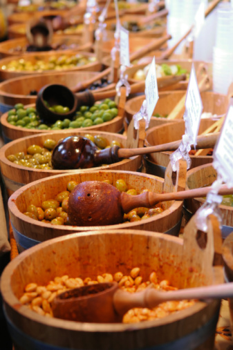 Marinated olives and beans in buckets for sale at market.