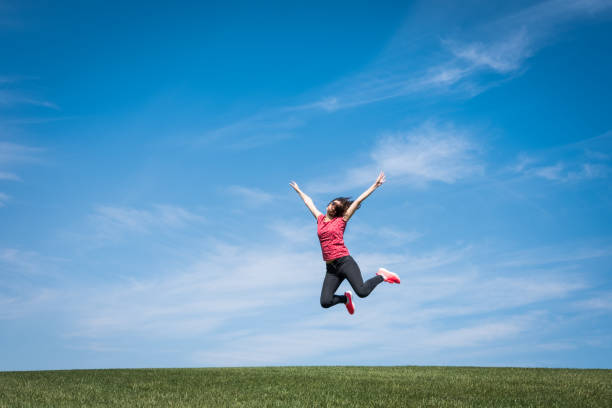 istock Pretty young woman jumping on green grass 1059520842