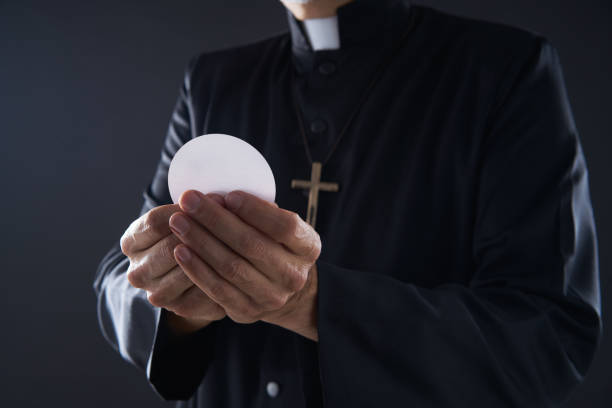 istock Communion wafer hostia priest in hands 1059524024