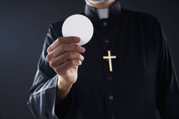 istock Communion wafer hostia priest in hands 1059524062