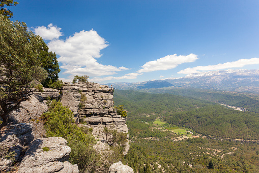 Young man sitting on top of cliff.