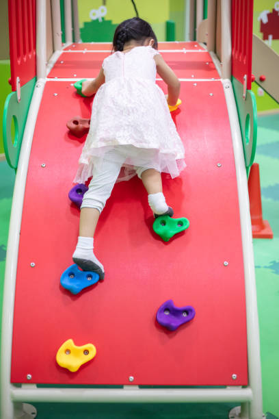 istock Asian Chinese little Girl playing at mini rock climbing wall 1059526310