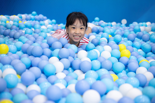 Asian Chinese little Girl Playing At Balls Pool in Indoor Playground