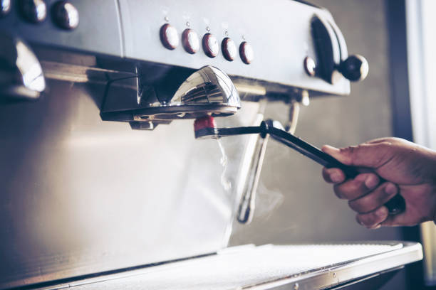 Barista cleaning coffee machine at coffee shop