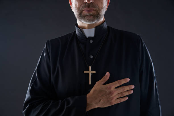 istock Priest hand in heart gesture with cross 1059535342