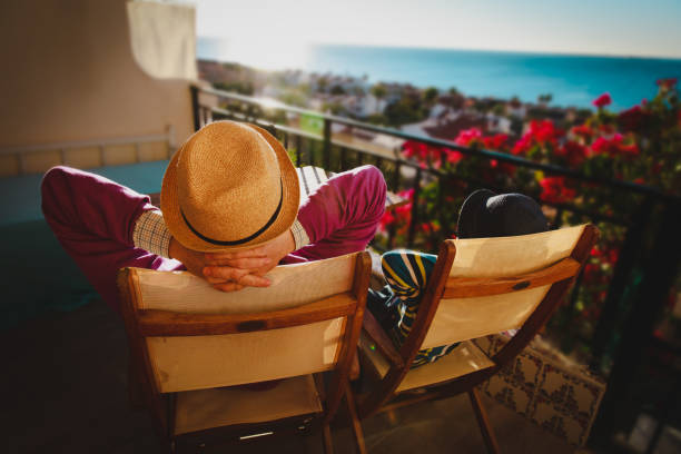 istock Dad and son relax on balcony terrace with sea view 1059535902