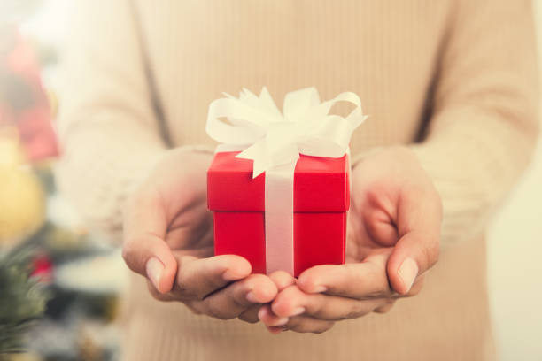 istock Woman hands giving red gift box 1059536668