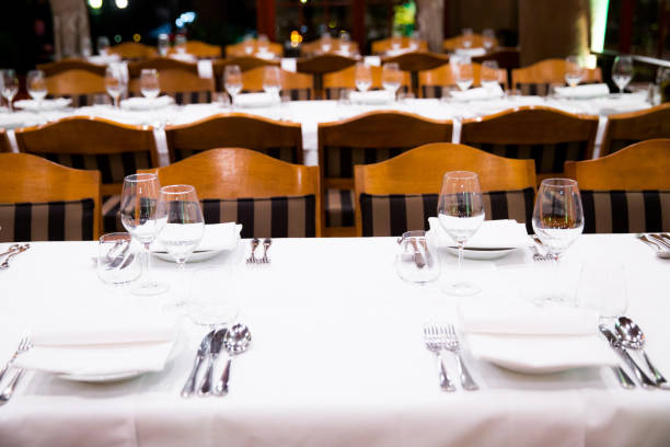 istock Beautifully decorated table with empty white plates, glasses and cutlery  on luxurious tablecloths 1059543120