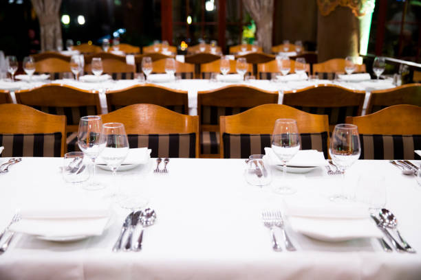 istock Beautifully decorated table with empty white plates, glasses and cutlery  on luxurious tablecloths 1059543154