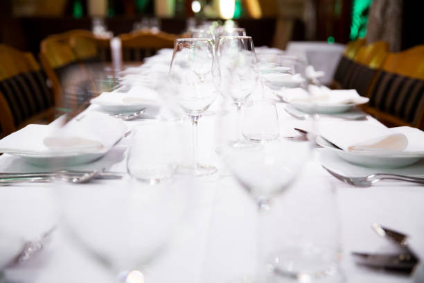 istock Beautifully decorated table with empty white plates, glasses and cutlery  on luxurious tablecloths 1059543310