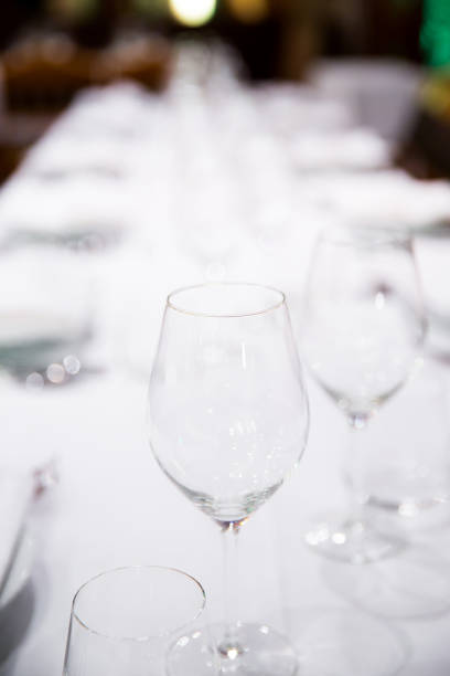istock Beautifully decorated table with empty white plates, glasses and cutlery  on luxurious tablecloths 1059543396