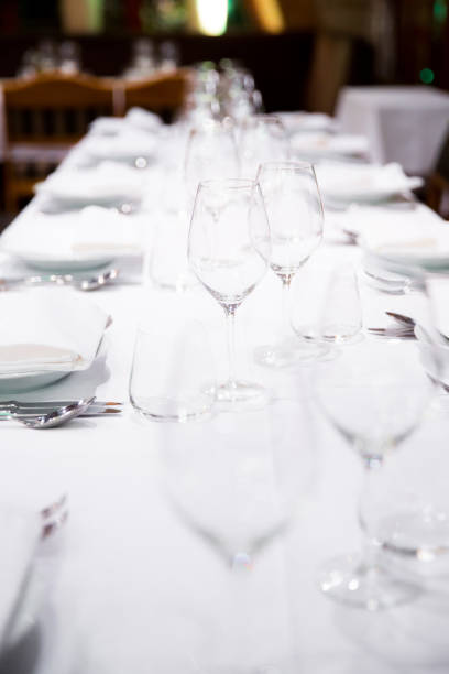 istock Beautifully decorated table with empty white plates, glasses and cutlery  on luxurious tablecloths 1059543426