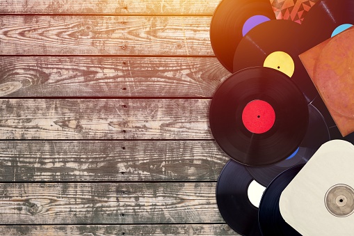 Retro styled image of a collection of old vinyl records on  background.
