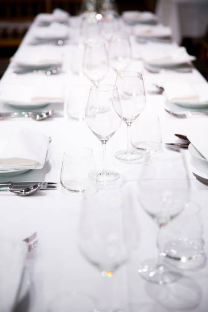 istock Beautifully decorated table with empty white plates, glasses and cutlery  on luxurious tablecloths 1059543498