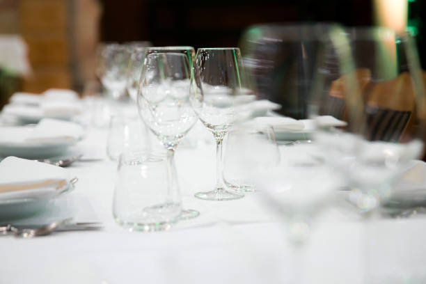 istock Beautifully decorated table with empty white plates, glasses and cutlery  on luxurious tablecloths 1059543668
