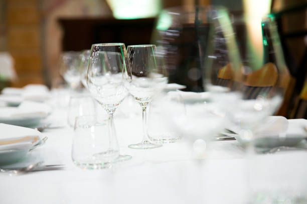 istock Beautifully decorated table with empty white plates, glasses and cutlery  on luxurious tablecloths 1059543722