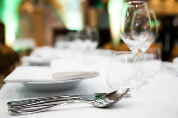 istock Beautifully decorated table with empty white plates, glasses and cutlery  on luxurious tablecloths 1059543812