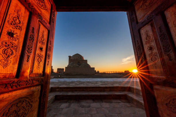 View over the mausolem through wooden doors at the sunset, in the ancient cemetery of Mizdakhan in Nukus, Uzbekistan Historical cemetery of Mizdakhan in Nukus, Uzbekistan khiva stock pictures, royalty-free photos & images