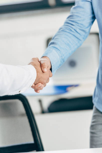 istock close-up partial view of businessmen shaking hands at workplace 1059551722