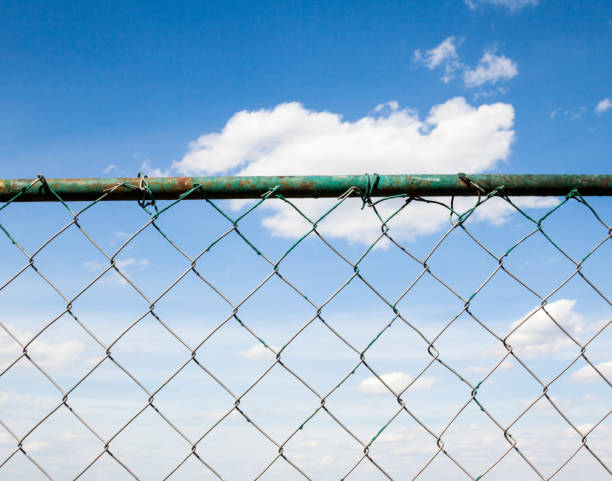 istock Blue sky behind the metal mesh fence 1059556204