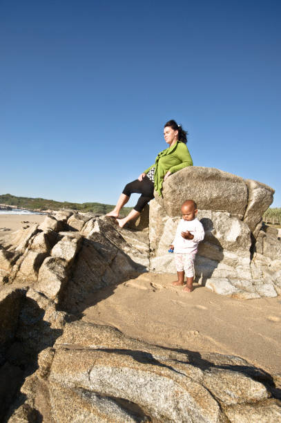 istock Young Family (Mother And Toddler) Posing By The Seaside. Clear Blue Sky Background 1059560876