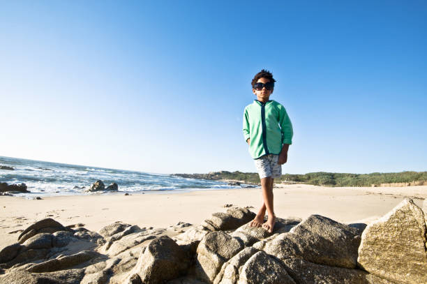 istock Little Boy Posing By The Seaside. Clear Blue Sky Background 1059561458