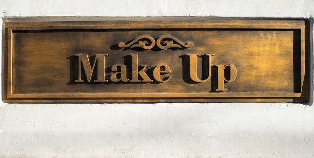 istock Gold embossed lettering Make Up on white wall. 1059563336