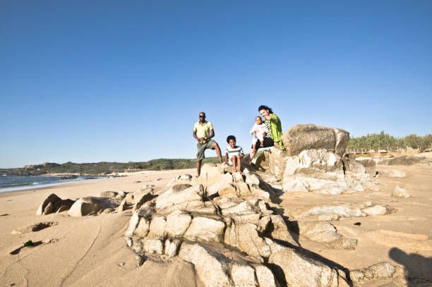 istock Young Family Posing By The Seaside. Clear Blue Sky Background 1059564182