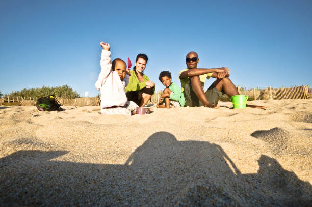 istock Young Family Posing On A Seaside Sand. Clear Blue Sky Background 1059567628